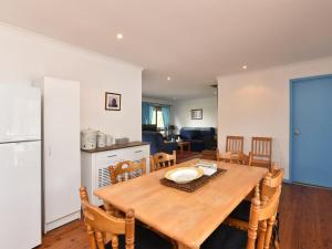 a kitchen and dining room with a wooden table and chairs at Wallaby Cottage in Ellalong