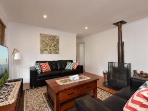 a living room with a couch and a fireplace at Australiana Cottages in Ellalong