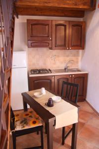 a small kitchen with a table and chairs and a sink at La Finestra Sotto La Rocca in Cefalù