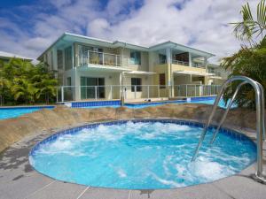 a house with a hot tub in front of a house at Pacific Blue 278-265 Sandy Pt Rd- Dual Key Access, Wifi, Linen and Air Conditioning in Salamander Bay