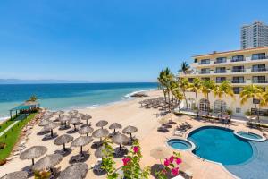 a beach with umbrellas and chairs and a hotel at Villa del Palmar Beach Resort & Spa Puerto Vallarta in Puerto Vallarta