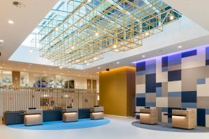a lobby with chairs and a ceiling with a glass at Holiday Inn Express Amsterdam - North Riverside by IHG in Amsterdam
