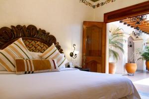 a bedroom with a large bed with a wooden headboard at Los Pilares Hotel in Oaxaca City +54 photos