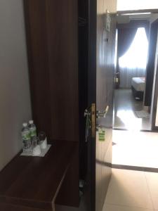 a door to a bathroom with bottles on a counter at Bunda Hotel Padang - Halal Hotel in Padang