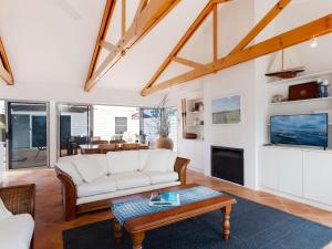 a living room with a white couch and a table at Corlette Retreat 1 fantastic waterfront property with air con in Corlette