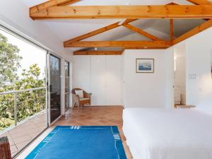 a bedroom with a bed and a large window at Corlette Retreat 1 fantastic waterfront property with air con in Corlette