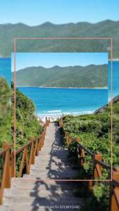 una imagen de un camino de madera que conduce a la playa en Solares | Verdes Mares, en Arraial do Cabo