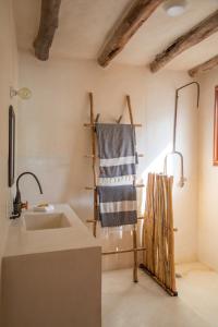 a bathroom with a sink and a towel on the wall at CASA CAT BA Beachfront Boutique Hotel in Holbox Island