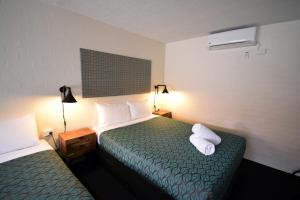 a hotel room with two beds and two lamps at Winsor Park Motor Inn in Albury