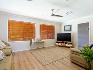 ホークス・ネストにあるBeach Houseのソファとテレビのあるリビングルーム