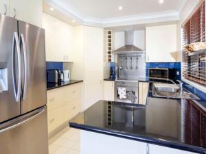 a large kitchen with a stainless steel refrigerator at Beach House in Hawks Nest