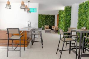 un comedor con sillas, mesas y plantas en Moderno y acogedor condominio en zona exclusiva en San Pedro Sula