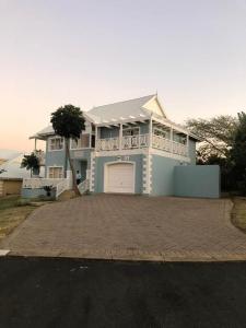 a large blue house with a large driveway at Caribbean Estates Villa 1131 in Port Edward