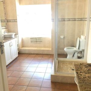 uma casa de banho com um chuveiro, um WC e um lavatório. em Caribbean Estates Villa 1131 em Port Edward