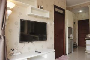a living room with a flat screen tv on the wall at Comfy & Strategic 2BR Gateway Pasteur Apartment near Pasteur Exit Toll By Travelio in Bandung +13 photos