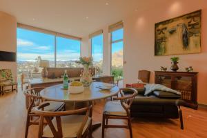 uma sala de estar com mesa e cadeiras em Lanah Residence em Queenstown