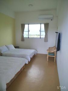 Habitación con 2 camas, TV y ventana. en Hao Homestay, en Taitung