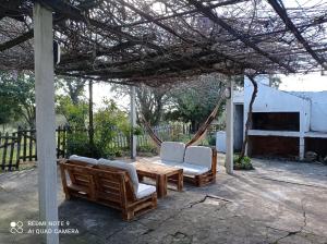 un patio con mesa, sillas y hamaca en POSADA, en Minas