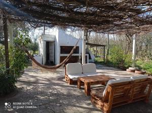 eine Terrasse mit Hängematte und Stühlen und ein Haus in der Unterkunft POSADA in Minas