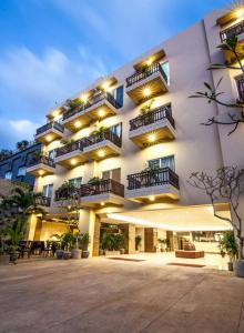 a large white building with balconies on it at The Tusita Hotel in Kuta