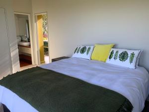 a bedroom with a large bed with pillows on it at Mangawhai Bay B&B in Omokoroa