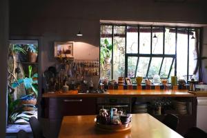 a kitchen with a counter and a table and windows at Maison d'Almes in Adissan