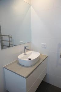 a white sink sitting under a mirror in a bathroom at Beachfront Motel in Apollo Bay