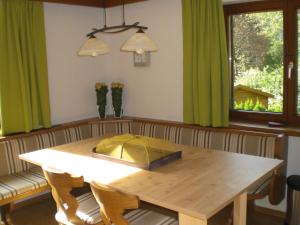 ein Esszimmer mit einem Holztisch und grünen Vorhängen in der Unterkunft Haus Oetz in Oetz