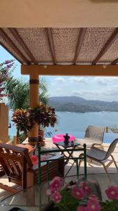a patio with a table and chairs and a view of the water at preciosa casa que ve al pacifico in Zihuatanejo