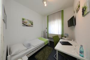 Pokój szpitalny z łóżkiem i biurkiem w obiekcie Rosenhotel w mieście Zweibrücken