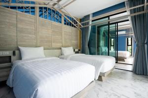 a bedroom with two beds and a window at Ao Cho Grandview Hideaway Resort in Ko Samed