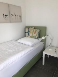 een slaapkamer met een bed met een lamp en een tafel bij Ferienhaus SEE & Ferienhaus SEEBLICK in Neukieritzsch