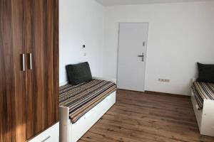 two beds in a room with white walls and wooden floors at Vikrimp in Norderstedt