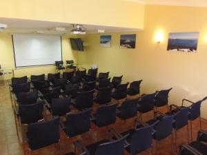 a lecture hall with chairs and a whiteboard at Hotel Departamentos del Sur in Puerto Montt