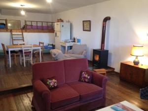 a living room with a couch and a kitchen and a table at Mistra Estates Villa The Vine in Pikouliánika