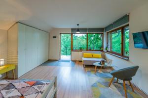 a living room with a couch and a table at Dragonfly Studio with GARDEN in Braşov