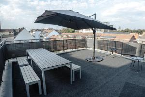 ミュンスターにあるStylisches Münster City-Apartment 83 m²のバルコニーの上にあるベンチと傘