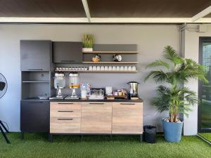 a kitchen with a counter with a counter at The Vet Boutique Hotel - SHA Extra Plus in San Kamphaeng