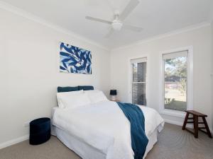 a white bedroom with a bed and a window at Calm at Shoal Bay in Shoal Bay