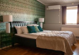 a bedroom with a large bed with green wallpaper at Hotell Ronja in Vimmerby +54 photos
