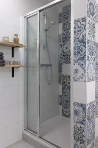 a shower with a glass door in a bathroom at INITIUM rooms - Pokoje na wynajem - Obrońców Wybrzeża 4D in Gdańsk