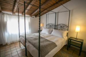 a bedroom with a bed with a metal canopy at Alla Giudecca in Syracuse