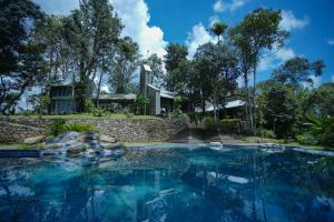 a swimming pool in front of a house at SpiceTree Rajakumari in Munnar