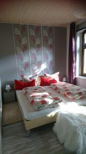 a bedroom with two beds with red and white pillows at Hansis Lodge in Klingenthal