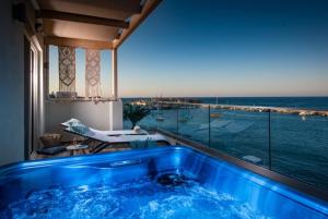 een blauw bad in een kamer met uitzicht op de oceaan bij Sonia Center in Chersonissos