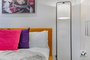 a bedroom with a bed with colorful pillows at KOZYGURU WOLLI CREEK KOZY 1 BED APT SYDNEY AIRPORT & SYDNEY CBD NWC020 in Sydney