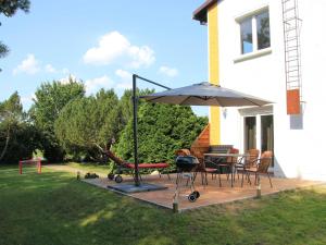 a patio with an umbrella and a table and chairs at Ferienwohnung am alten Gutshaus in Nossentin