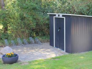 a group of chairs sitting in front of a shed at Ferienwohnung am alten Gutshaus in Nossentin
