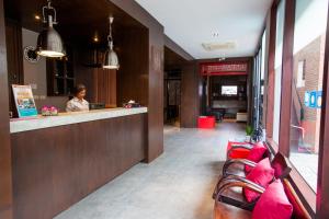 a woman sitting at a bar in a restaurant at Amenity Apartel Samui in Lamai