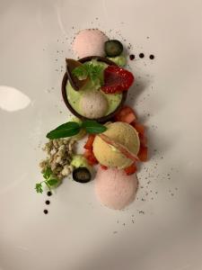 a white plate with a dessert with fruits and vegetables at Hotel Vista Allegra in Ischgl